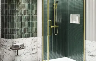 Quadrant shower enclosure with brushed brass frame and vertical green tiles