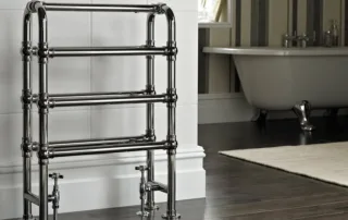 Traditional chrome heated towel rail with vintage-style bathroom in the background