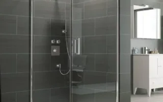 Frameless glass shower enclosure with infold door and large grey wall tiles
