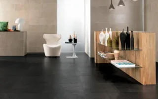 Contemporary room with large black porcelain floor tiles and wooden shelving