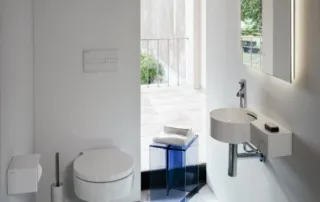 Minimalist white cloakroom with compact round basin and wall-hung toilet on marble flooring