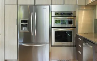 Modern kitchen with stainless steel fridge and built-in ovens