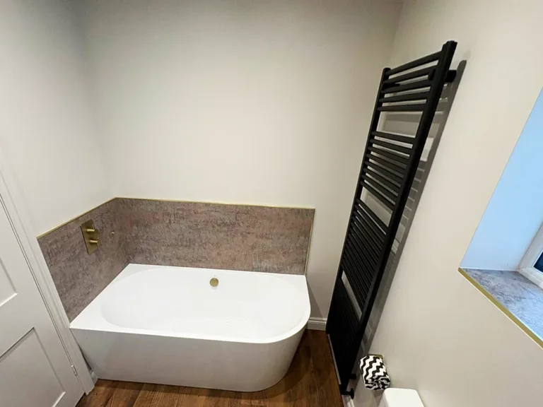 modern bathroom with freestanding bath brushed brass controls and black heated towel rail