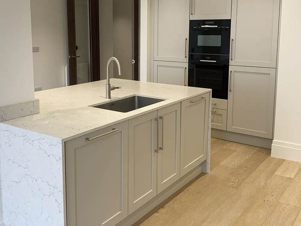 Sheraton kitchen island with painted limestone doors and Algarve worktop installed in a North West London apartment