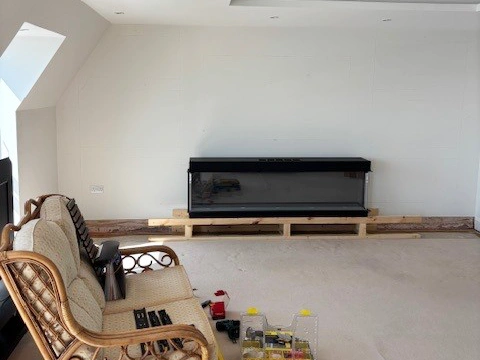 Initial construction stage of a media wall showing the stud framework and inset electric fire before boarding and plastering